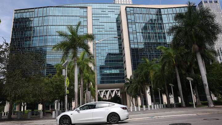 Um veículo da Tesla passa pelo Tribunal Federal Wilkie D. Ferguson Jr. enquanto a seleção do júri começou em conexão com alegações sobre a segurança do sistema de piloto automático da Tesla em 14 de julho de 2025, em Miami, Flórida. (Foto: Joe Raedle | Getty Images)