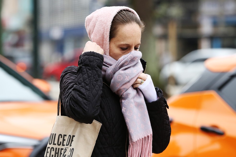 Temperaturas sobem e regiões se livram do frio até segunda-feira Mulher protege rosto do frio em Curitiba (PR). (Foto: Giuliano Gomes/PR Press/Estadão Conteúdo)