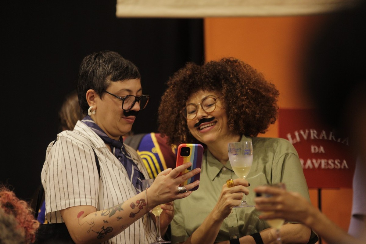 Natália Borges Polesso (com celular na mão) e Luciany Aparecida em sarau na Casa Toda Poesia (Foto: Alexandre Cassiano/ Agência O GLOBO)