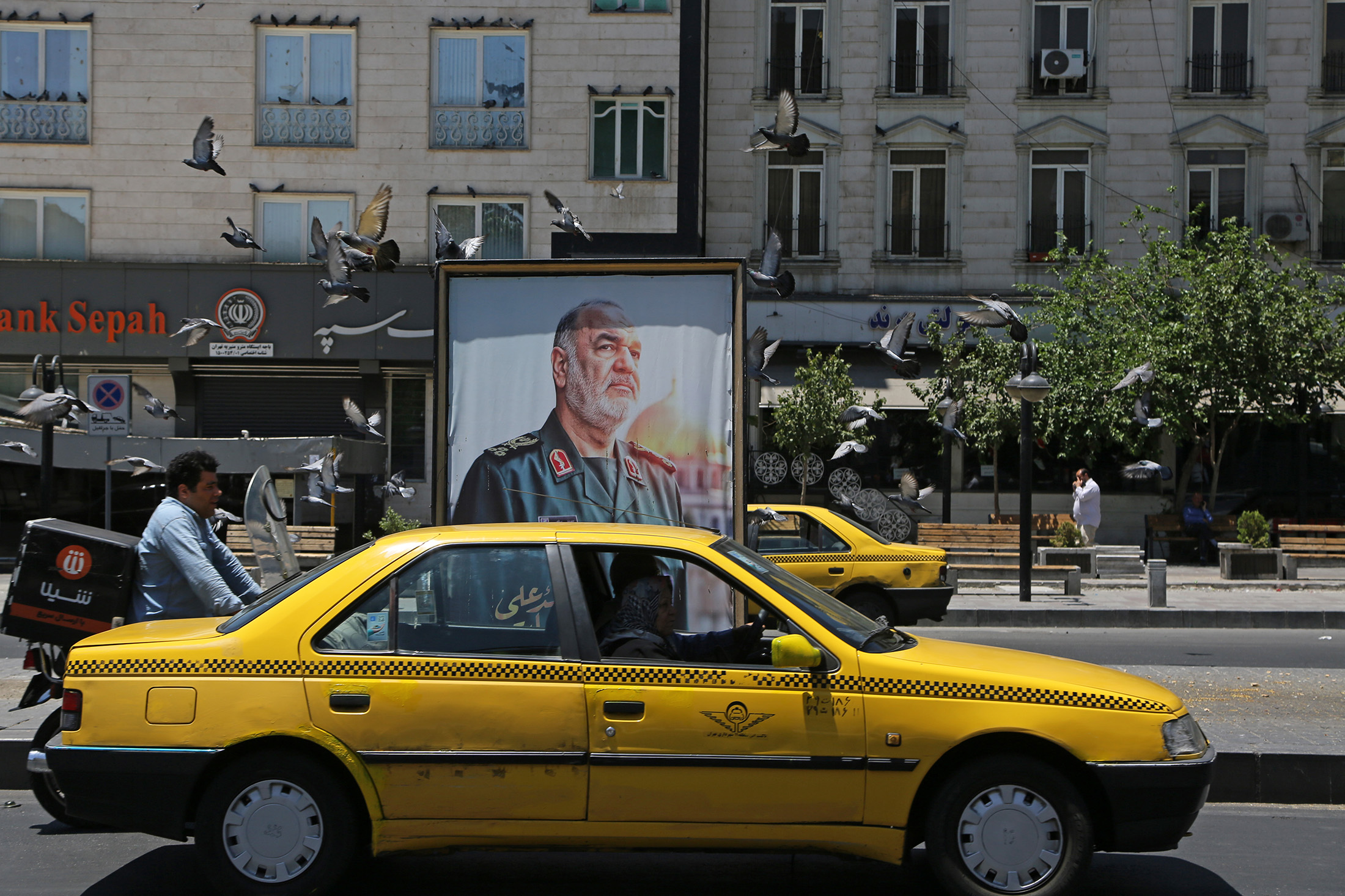 Um cartaz com a imagem do Comandante-em-Chefe do IRGC, Hossein Salami, exibido em frente a uma agência do Banco Sepah em Teerã, em 17 de junho. (Foto: Fatemeh Bahrami/Anadolu/Getty Images/Via Bloomberg)