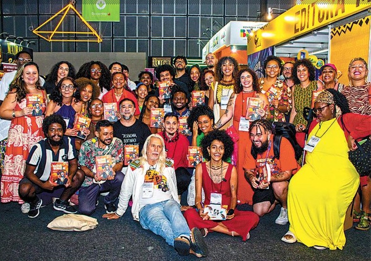 Flup impulsiona literatura periférica e publica 35 novos livros de escritores talentosos Celebração. Autores de “Machado Quebradeiro” e, no centro, de branco, Julio Ludemir, criador da Flup, no lançamento da obra na Bienal do Livro (Foto: Anderson Baptista / Divulgação)