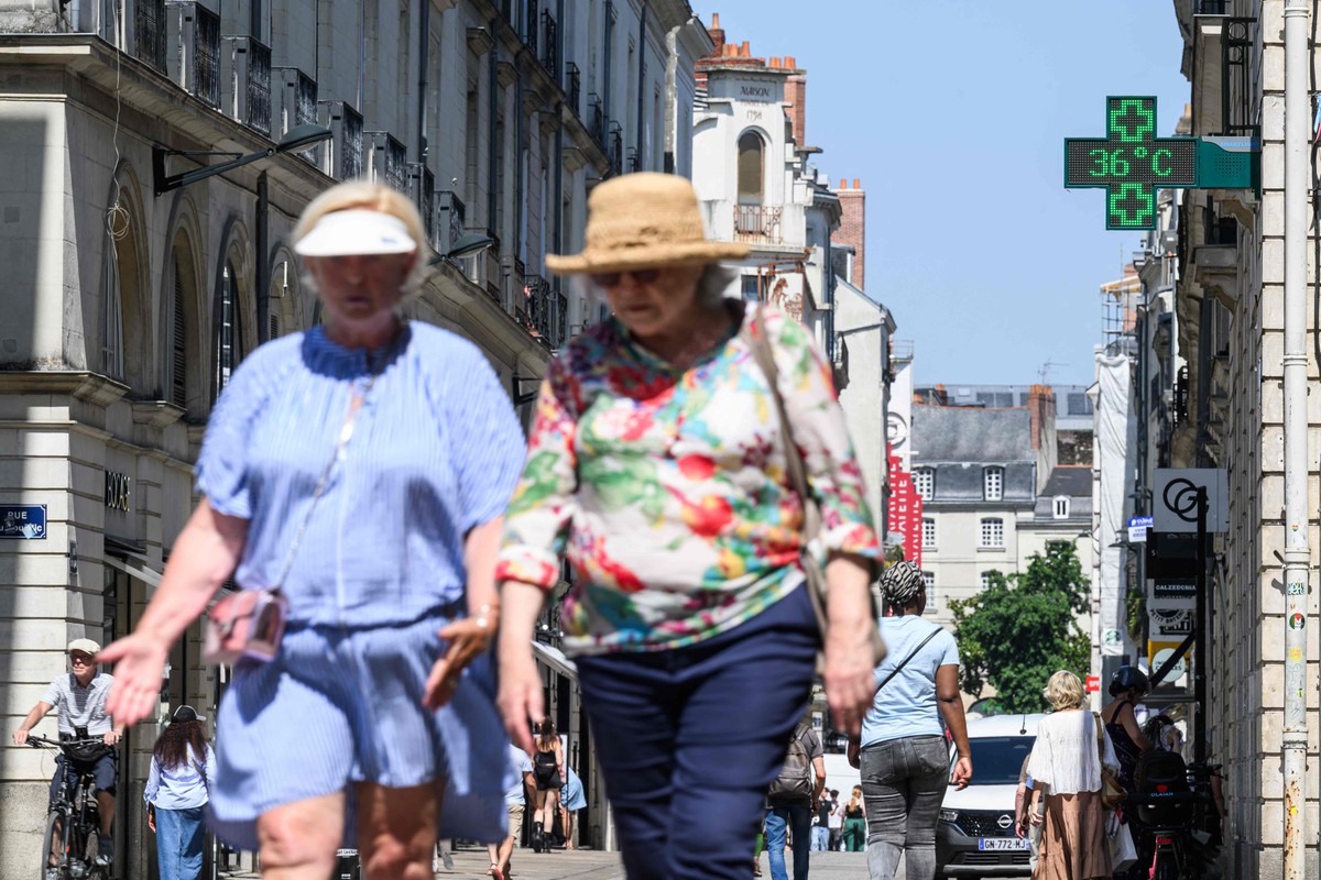 França enfrenta intensa onda de calor com temperaturas chegando a 39ºC Pessoas caminham pela rua enquanto um termômetro indica temperatura de 36ºC durante onda de calor no centro de Nantes, oeste da França (Foto: Loic Venance/AFP)