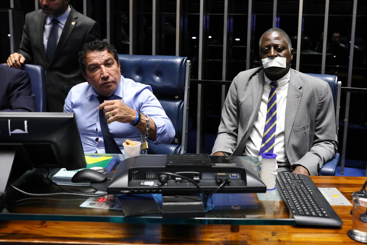 Senador Magno Malta e o deputado Hélio Lopes, do PL, acorrentados na mesa do plenário do Senado (Foto: Reprodução)