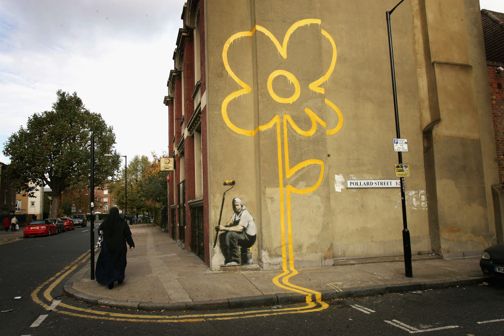 Mural de Banksy provoca disputa judicial entre clube e ex-colaborador A imagem "Indo, indo, indo... ido": O 'Pintor de Flores das Linhas Amarelas' de Banksy foi removido de sua parede original em Londres e foi colocado à venda nos EUA. (Foto: Getty Images)