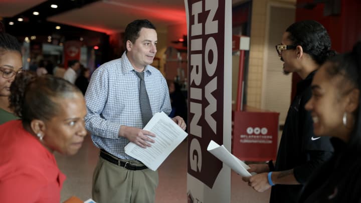 Mitch Graham (C) pergunta sobre empregos na Triton Recovery durante a Mega JobNewsUSA South Florida Job Fair realizada na Amerant Bank Arena em 30 de abril de 2025, em Sunrise, Florida. (Foto: Joe Raedle | Getty Images)
