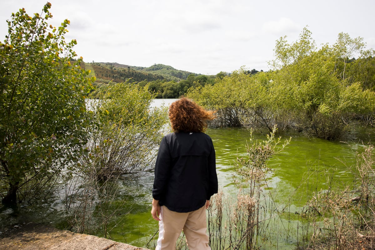 Uma vizinha contempla a água contaminada por cianobactérias em As Conchas (Lobeira). (Foto: ÓSCAR CORRAL)
