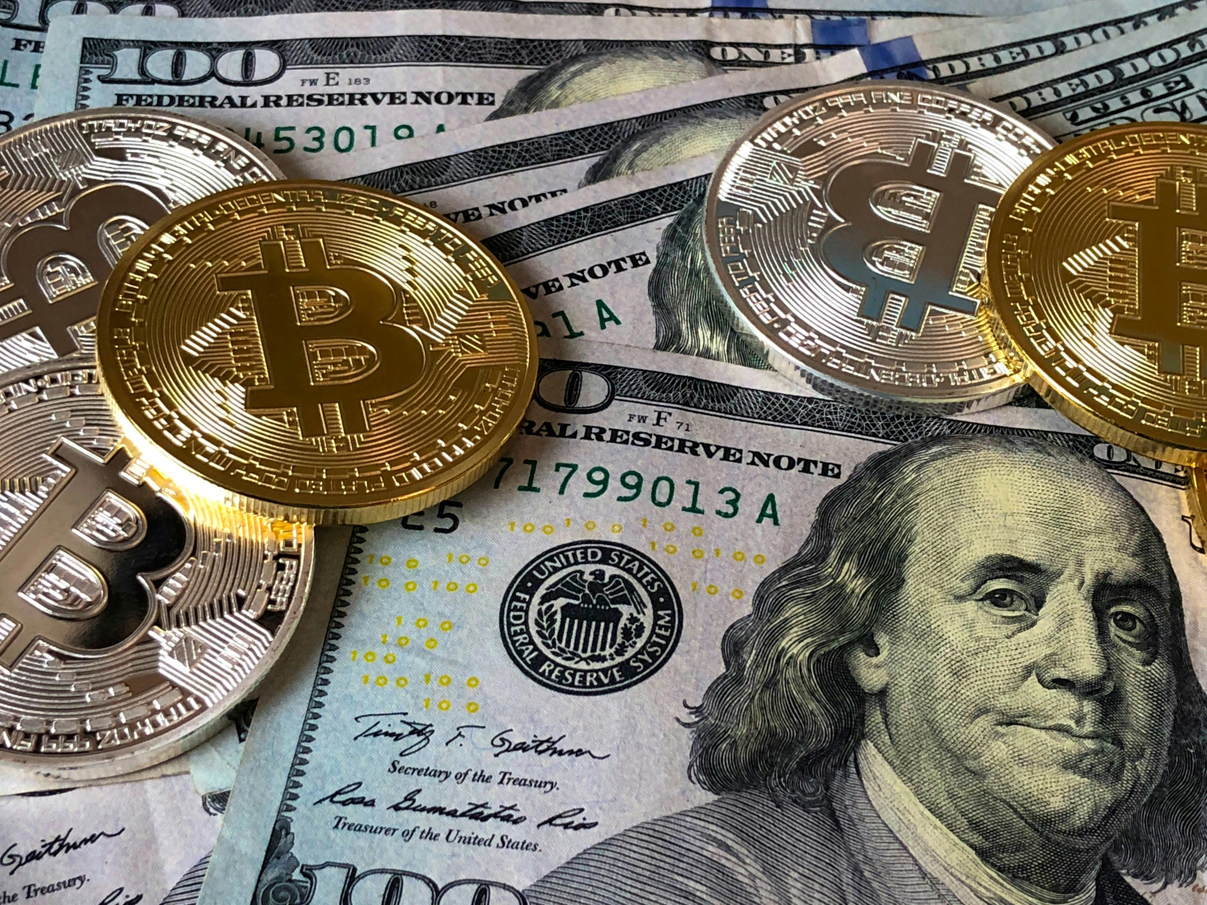 Representação de diversificação de ativos com dólares e representações físicas de Bitcoin e criptoativos (Foto: Pexels / David McBee)