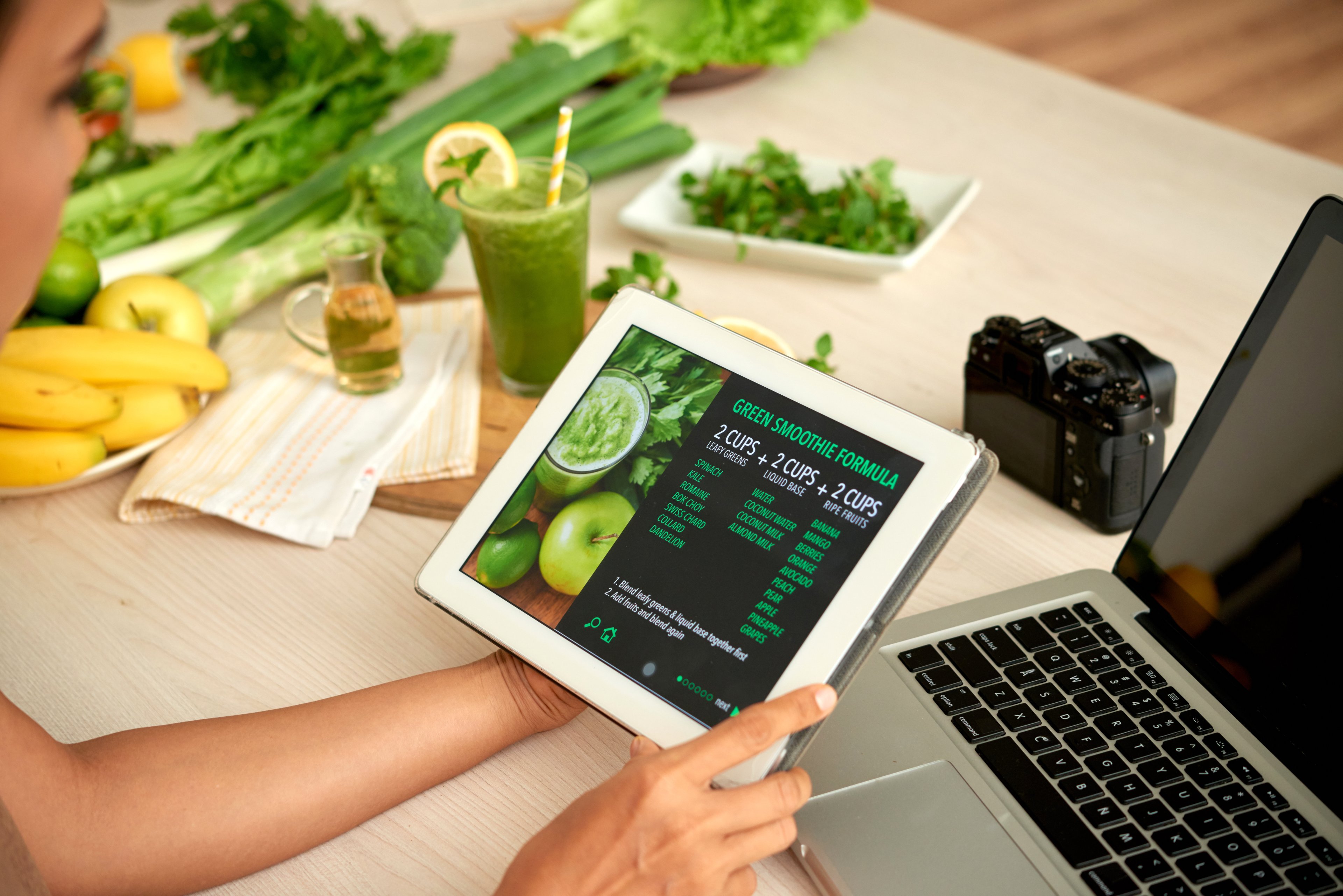 Plantas em ambientes de venda impulsionam a comercialização de alimentos saudáveis Mulher lendo fórmula de smoothie verde em tablet digital (Foto: Freepik)