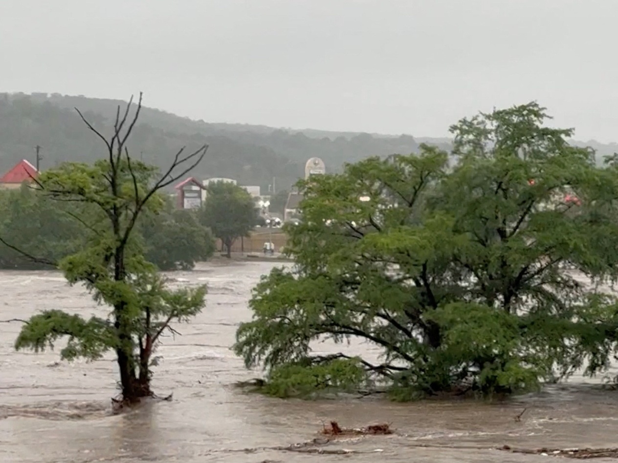 Professora busca mãe e quatro familiares desaparecidos após enchente no Texas Árvores ficam parcialmente submersas depois que tempestades causaram grandes inundações no rio Guadalupe, em Kerrville, Texas, EUA (Foto: Michael Moad/Reuters)