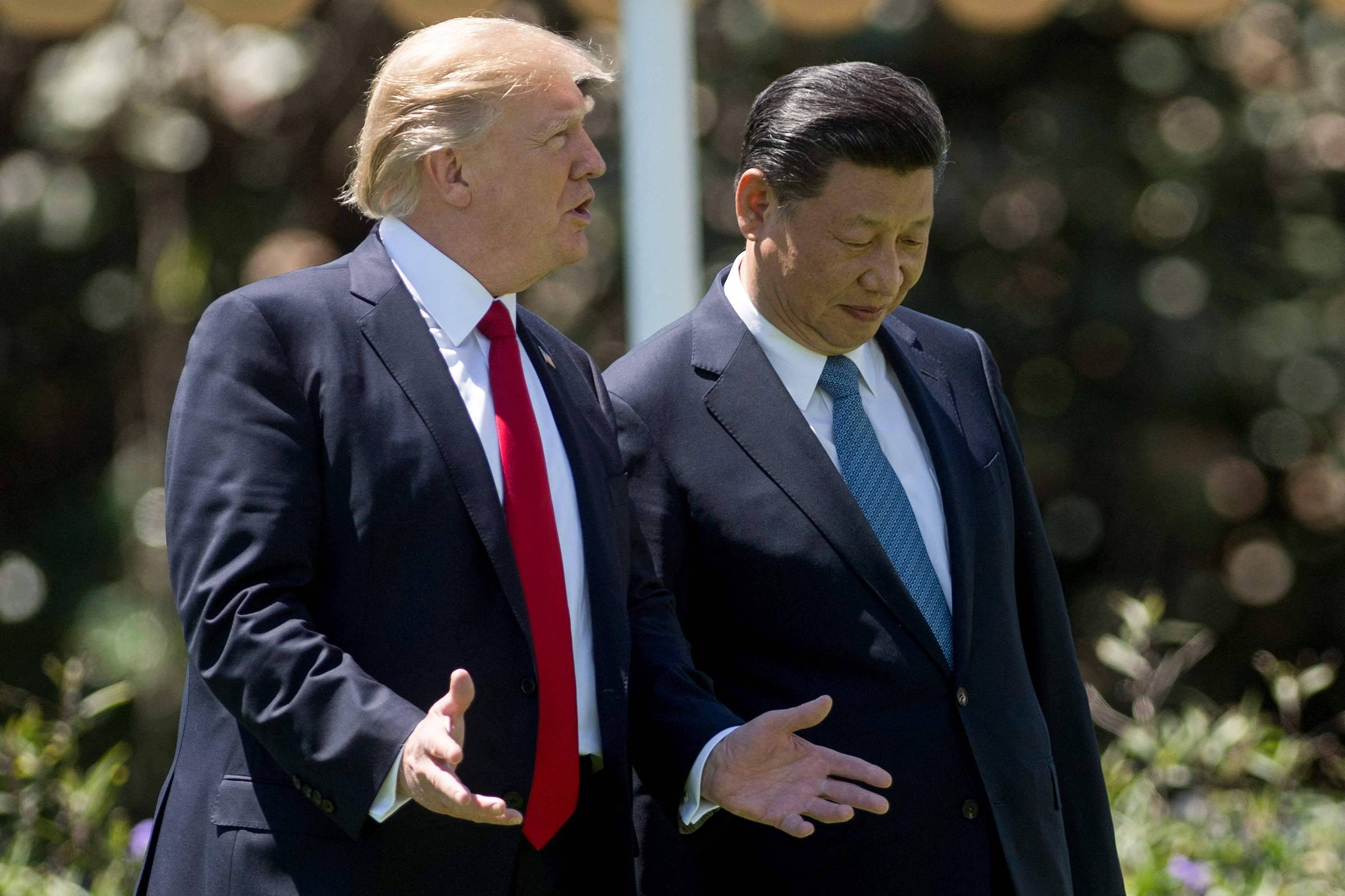 Donald Trump e Xi Jinping caminham juntos na propriedade Mar-a-Lago em Palm Beach, Flórida. - 7.abr.17 (Foto: JIM WATSON/AFP)