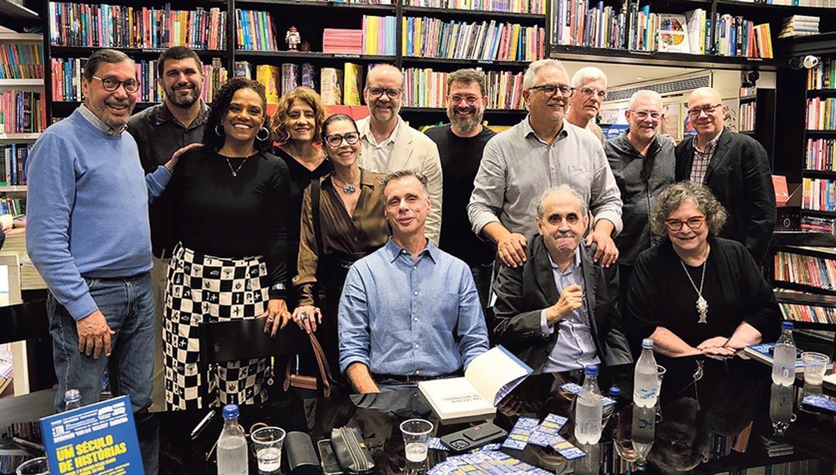 lançamento de 'Um século de Historias': a partir da esquerda, Merval Pereira, André Miranda, Flávia Oliveira, Míriam Leitão, Mànya Millen, Alan Gripp, Lauro Jardim (sentado), Pedro Doria, Ascanio Seleme, Ancelmo Gois (sentado), Toninho Nascimento, Agostinho Vieira, Arthur Dapieve e Cora Rónai (Foto: Alexandre Cassiano)