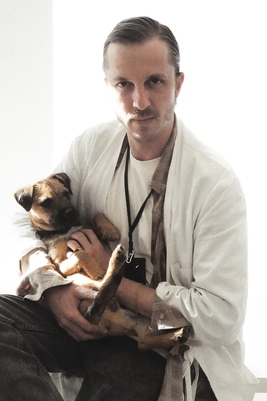 Glenn Martens promete estreia impactante na alta-costura da Maison Martin Margiela Glenn Martens fotografado segurando Murphy, seu cachorro (Foto: Divulgação)