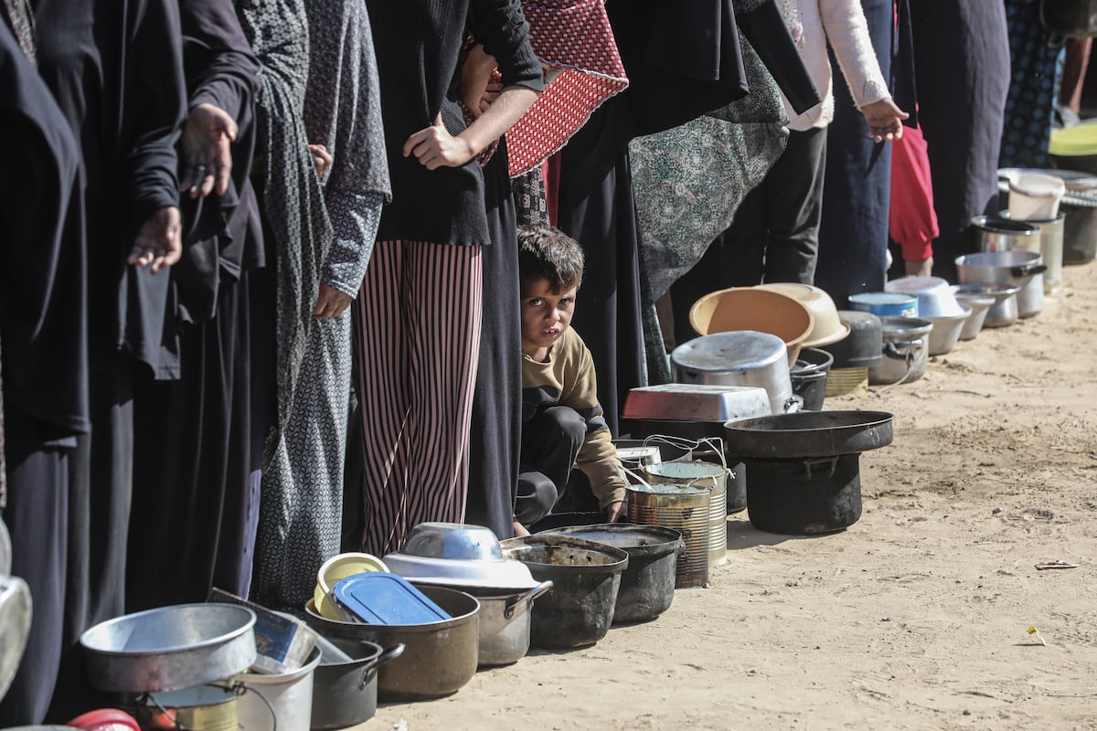 Famílias palestinas fazem fila para receber alimentos em Deir al Balah, Gaza, no dia 18 de novembro de 2024. (Foto: Omar Ashtawy / Apaimages / Zuma Press / Contacto)