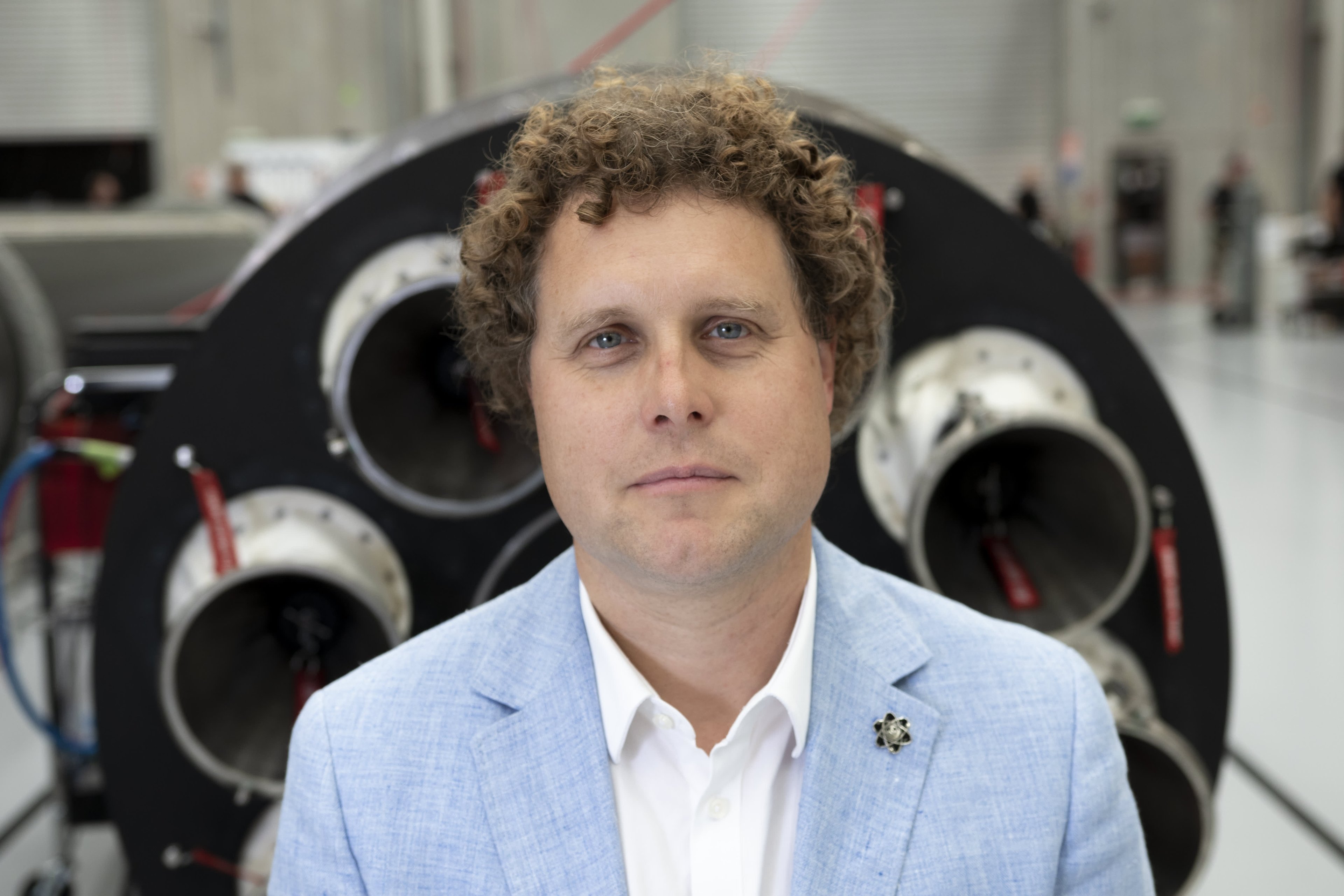CEO acorda às 4h30, evita reuniões e pilota helicóptero em sua rotina diária Peter Beck, CEO da Rocket Lab, posando de terno azul claro (Foto: Rocket Lab)