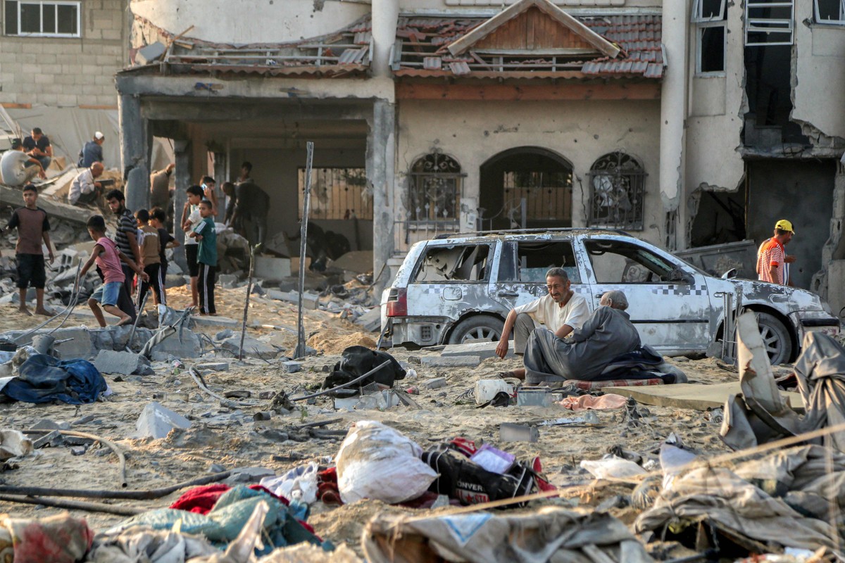 Oposição em Israel classifica guerra em Gaza como 'fracasso estratégico' e pede fim do conflito Pessoas em rua de Khan Yunis, no sul da Faixa de Gaza, após bombardeio israelense (Foto: AFP)