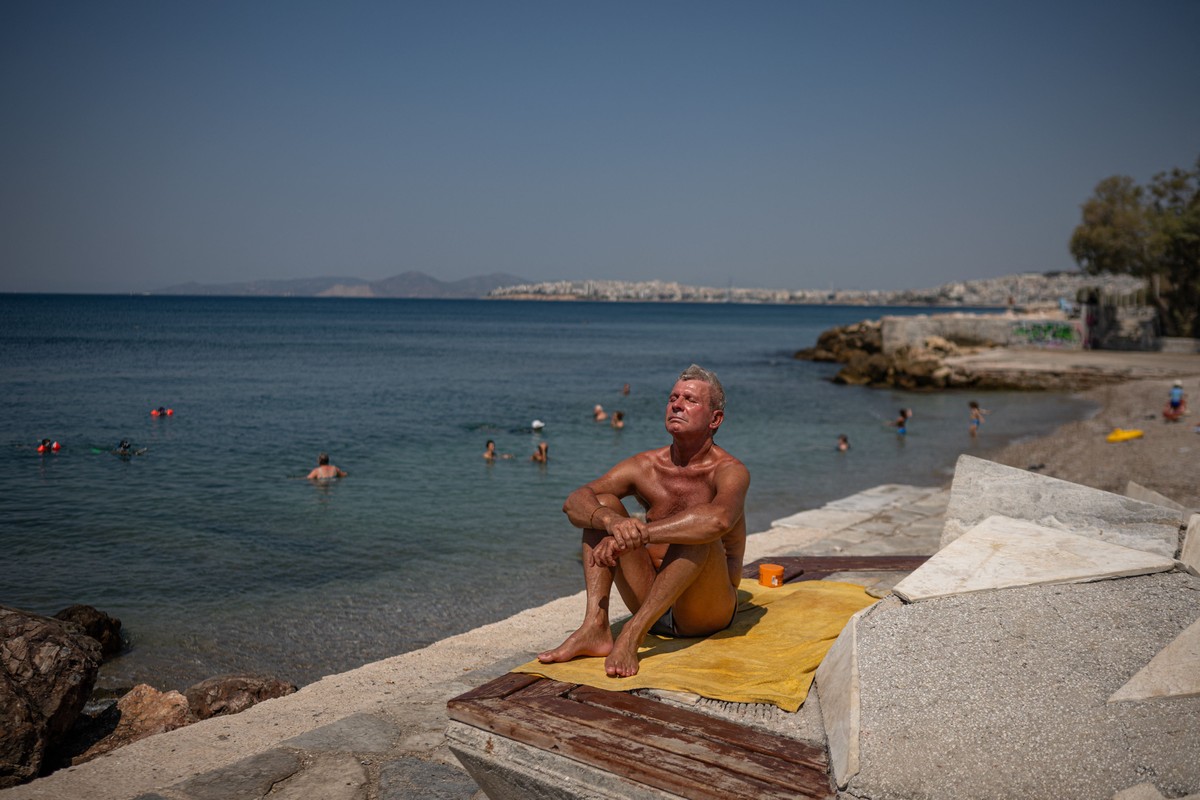 Grécia registra recorde de 45,8°C em meio a onda de calor intensa Homem curte praia em Atenas, na Grécia; regiões registraram 45,8°C durante onda de calor que atinge o país (Foto: Angelos Tzortznis/AFP)