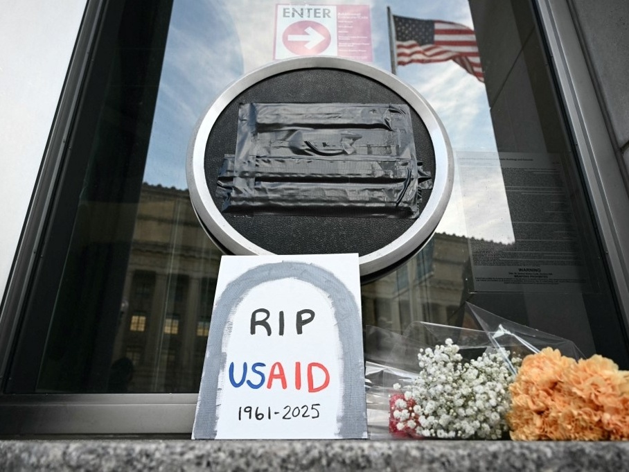 Tributos foram colocados na porta da sede da Usaid após cortes na agência pela gestão de Donald Trump (Foto: Mandel NGAN / AFP)