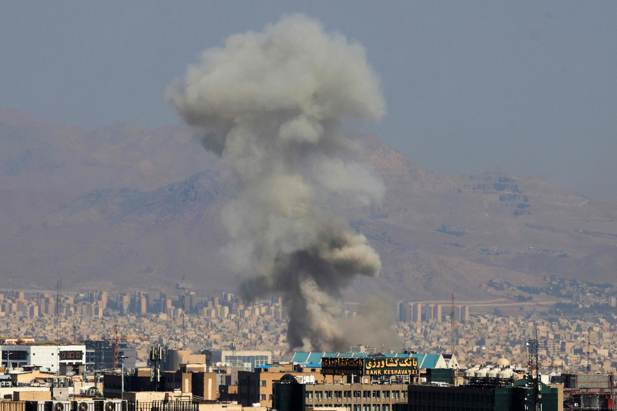 Anistia Internacional solicita investigação de ataque israelense a prisão no Irã Coluna de fumaça é vista no centro de Teerã após ataque israelense (Foto: Atta KENARE / AFP)