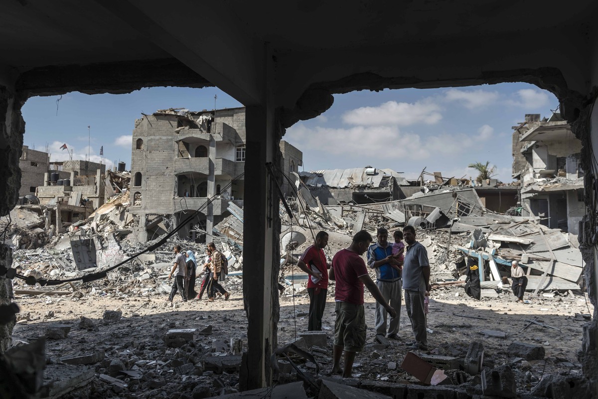 União Europeia cobra ações efetivas para enfrentar crise humanitária em Gaza Palestinos ao lado de casas destruídas por bombardeios israelenses em Beit Hanoun, no norte da Faixa de Gaza, em 26 de julho de 2014. (Foto: Sergey Ponomarev / The New York Times)