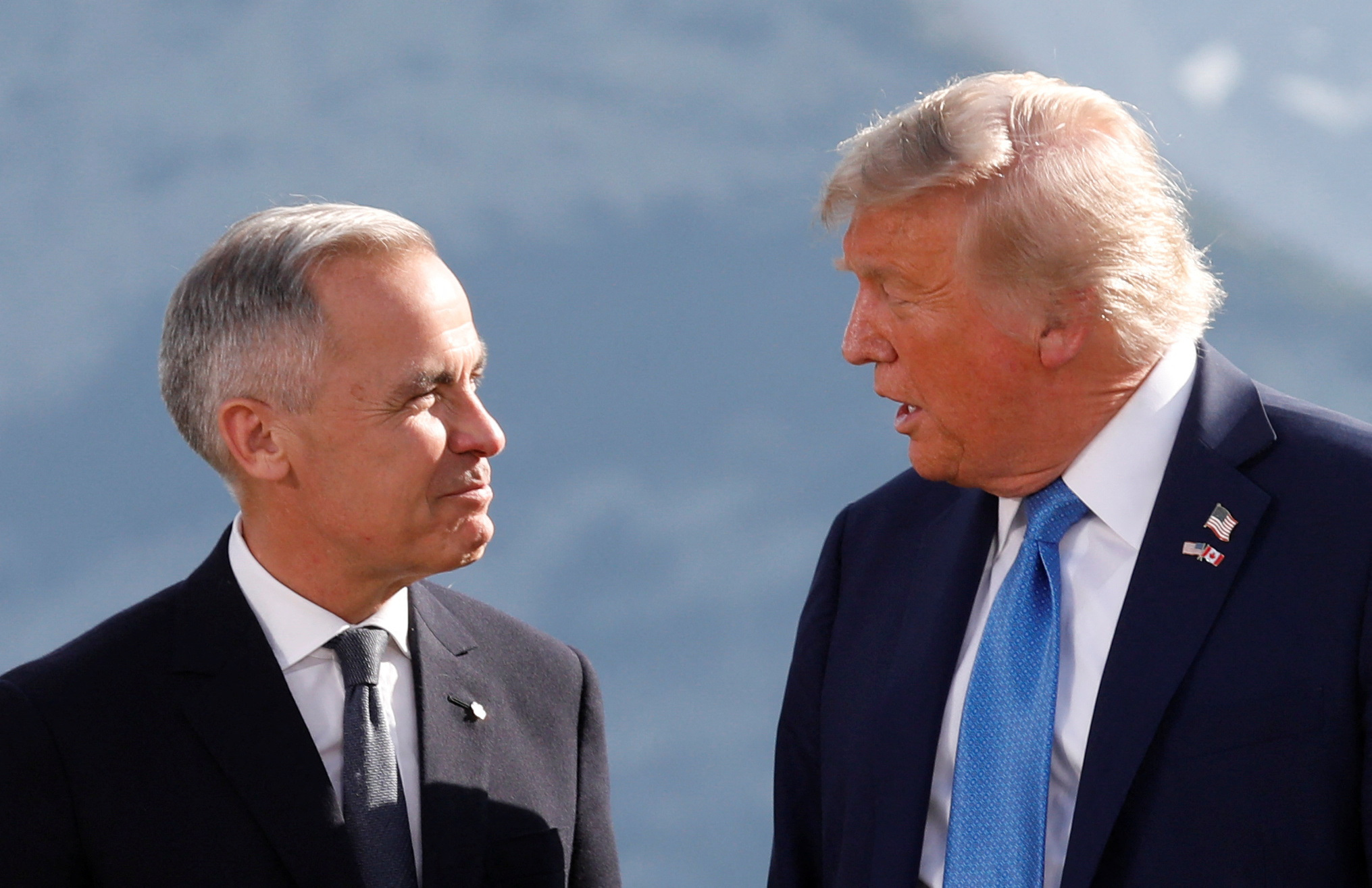 Canadá e EUA intensificam negociações e tarifas podem ser implementadas em breve O presidente dos EUA, Donald Trump, e o primeiro-ministro do Canadá, Mark Carney, conversam durante uma foto de família na Cúpula do G7 em Kananaskis, Alberta, Canadá, em 16 de junho de 2025. (Foto: REUTERS/Amber Bracken)