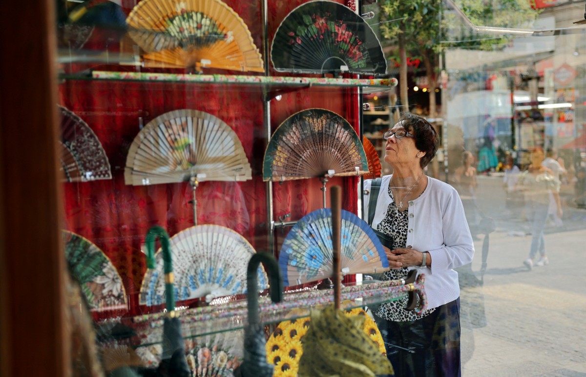Leques de luxo se destacam na Europa durante onda de calor com preços até R$ 38 mil Uma mulher olha a vitrine da loja de leques Casa de Diego, em Madri (Foto: Thomas Coex/AFP)