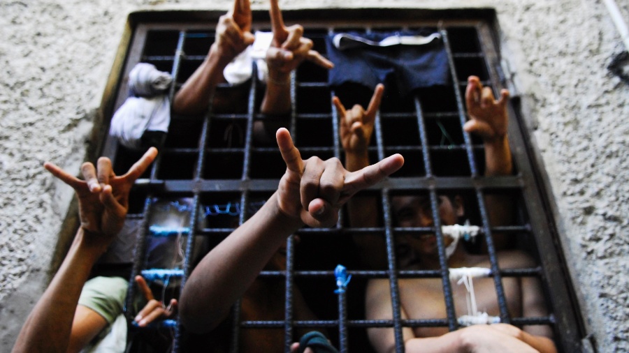 Trump promete erradicar a gangue MS-13 envolvida em violência e corrupção Presos integrantes da gangue Mara Salvatrucha ou MS-13, que atua nos Estados Unidos e na América Central, posam fazendo o sinal do grupo em delegacia de San Salvador (Foto: Ulises Rodriguez/Reuters)