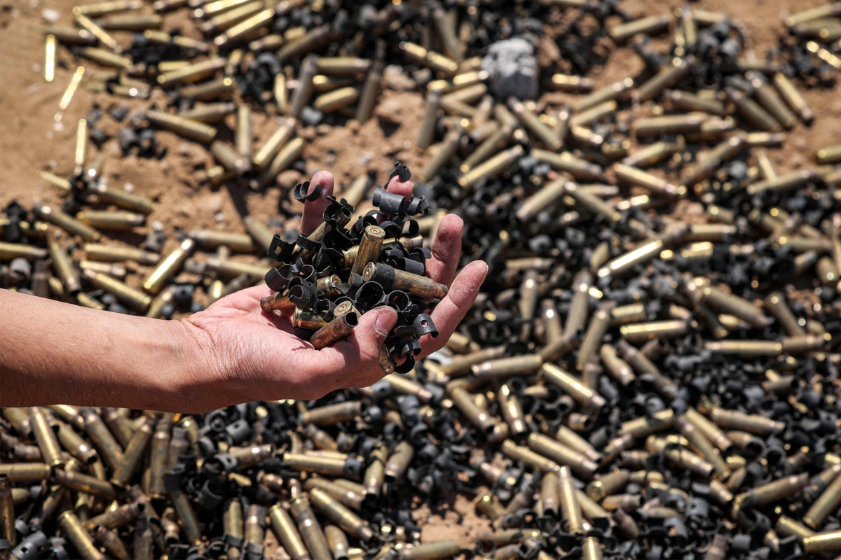 Pessoa segura cápsulas de munição em Khan Yunis, na Faixa de Gaza, após retirada temporária das tropas israelenses da área (Foto: AFP)