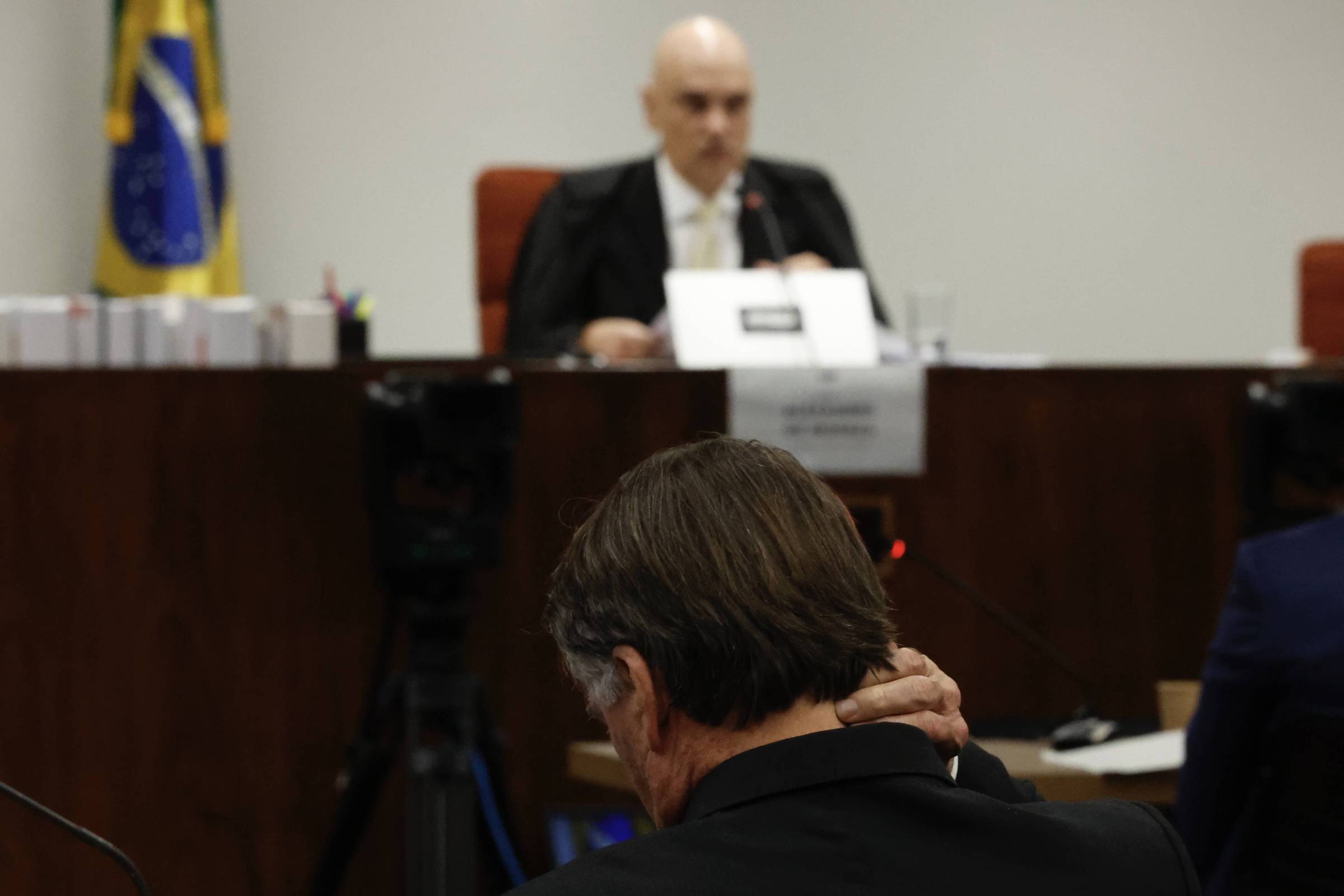 Supremo debate cautela em meio a tensões sobre casos de Bolsonaro e Trump O ex-pesidente Jair Bolsonaro durante sessão de depoimentos dos réus pela trama golpista. O ministro Alexandre de Moraes, ao fundo, presidiu a audiência (Foto: Pedro Ladeira - 10.jun.25/Folhapress)