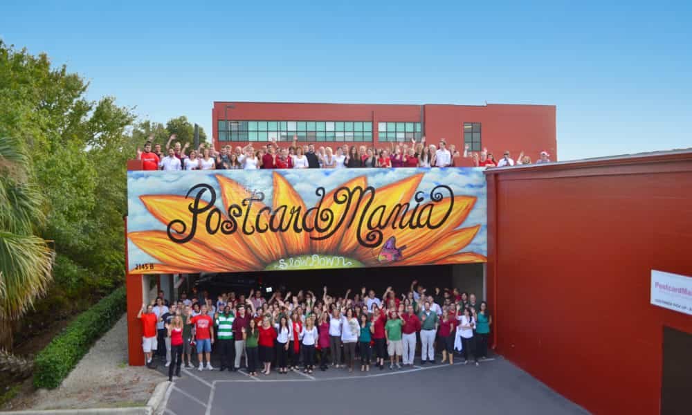 Erro de marketing gera US$ 1 milhão e inspira a valorização das raízes Time da PostcardMania posando na sede da empresa, na Flórida (Foto: St Pete Catalyst/Reprodução)