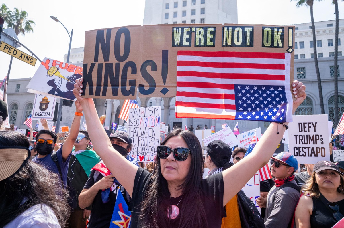 Manifestante com cartaz escrito 'Sem Reis' e 'Nós não estamos bem', em ato contra o presidente dos EUA, Donald Trump, em Los Angeles (Foto: RINGO CHIU / AFP)