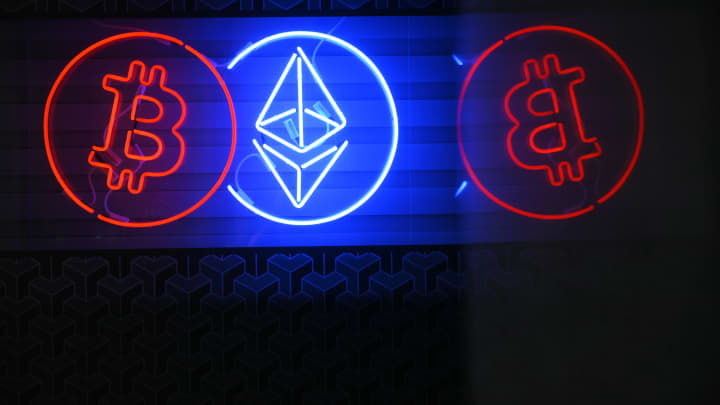 Pessoas caminham pasto um letreiro de neon anunciando uma troca de criptomoedas Bitcoin e Ethereum em Varsóvia, Polônia, em 19 de maio de 2024. (Foto: Jaap Arriens | Nurphoto | Getty Images)