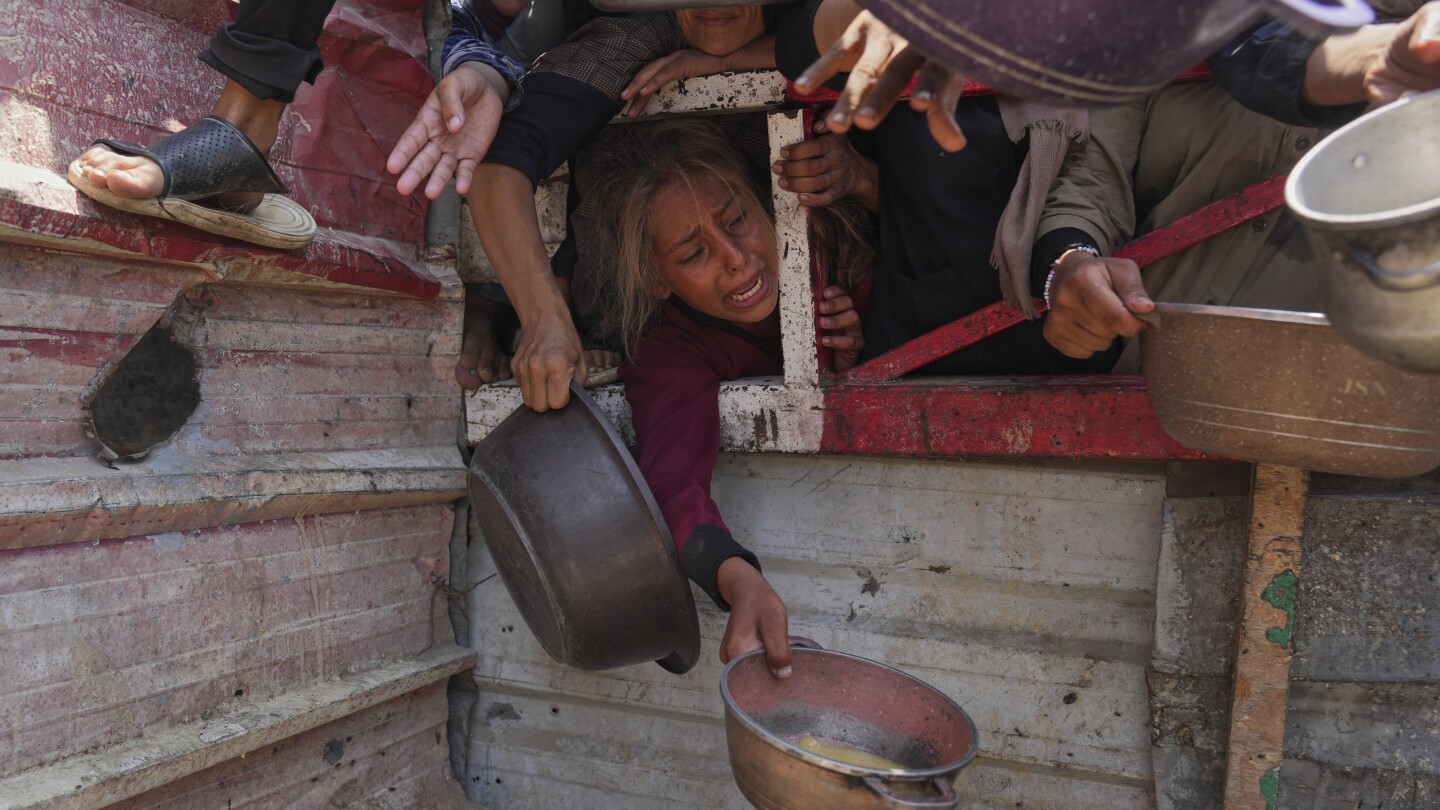 Palestinos lutam para conseguir alimentos doados em uma cozinha comunitária, na Cidade de Gaza, norte da Faixa de Gaza, sábado, 26 de julho de 2025. (Foto: AP Photo/Abdel Kareem Hana)
