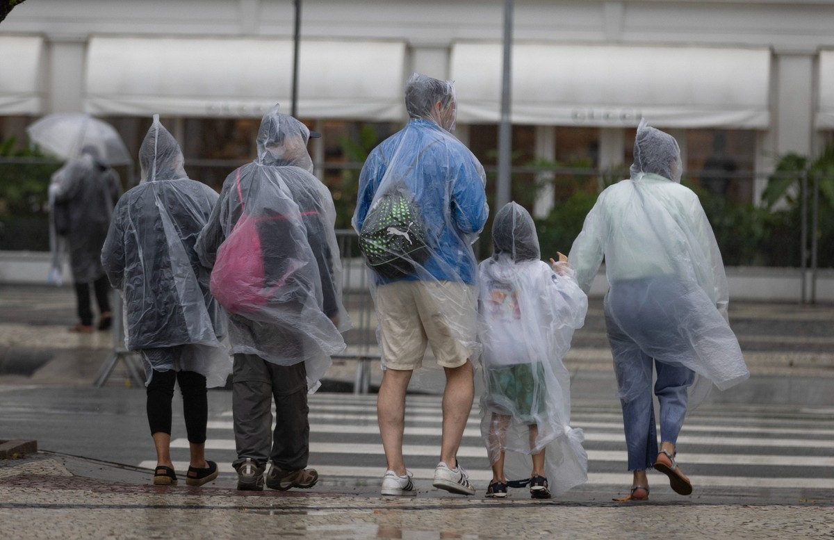 As capas de chuva foram tiradas dos armários — Foto: Márcia Foletto/Agência O Globo