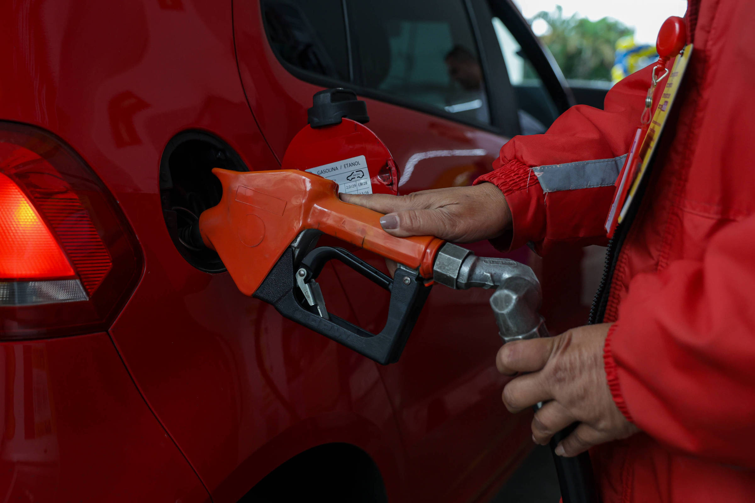 Postos mantêm preços altos da gasolina mesmo após redução nas refinarias da Petrobras Funcionária abastece carro de cliente em posto de combustíveis na zona sul de São Paulo. (Foto: Allison Sales/Folhapress)
