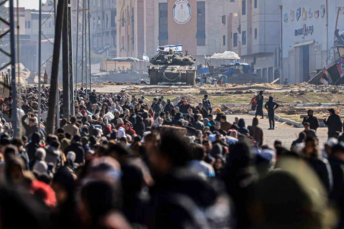 Tanque israelense e outros veículos militares se preparam enquanto os palestinos fogem de Khan Yunis, no sul da Faixa de Gaza (Foto: Mahmud Hams / AFP)