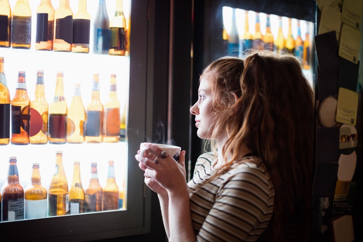 Deixar de beber álcool provoca mudanças significativas no corpo a partir do primeiro dia Mulher observa a prateleira de álcool (Foto: Freepik)