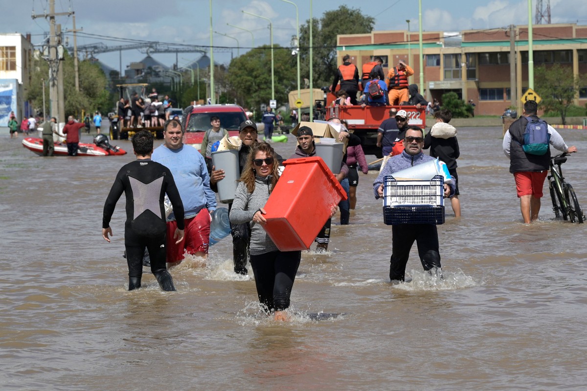 Milei nega auxílio a cidade argentina devastada por inundações recentes Pessoas que tiveram suas casas inundadas tentam salvar alguns pertences, em Bahia Blanca, na Argentina (Foto: AFP)