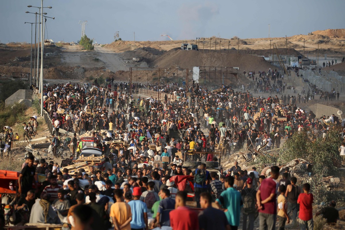 EUA buscam avançar em acordo para paz após trégua entre Irã e Israel em Gaza Civis palestinos se amontoam em busca de alimentos e outros insumos em posto de distribuição de ajuda na região central da Faixa de Gaza (Foto: Eyad BABA / AFP)