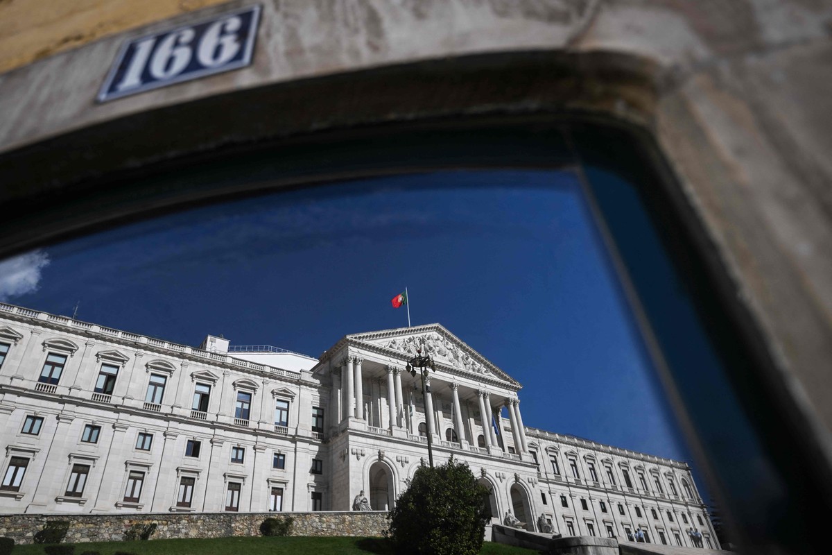 Parlamento de Portugal reflete no vidro de uma janela (Foto: Patrícia de Melo Moreira/AFP)