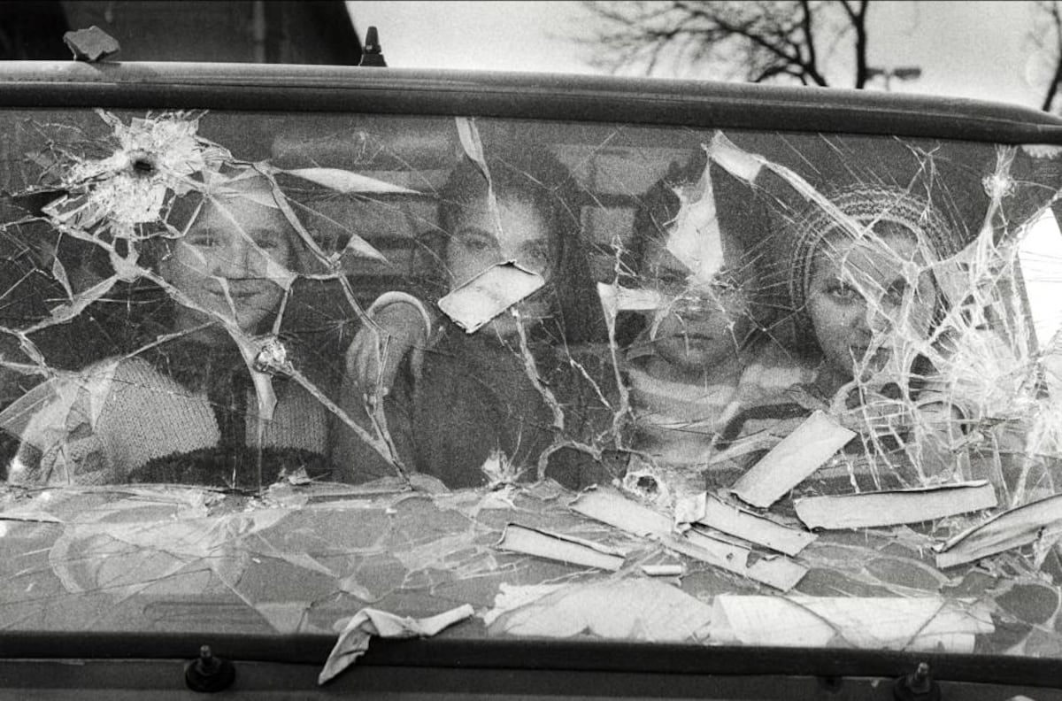 Gervasio Sánchez revela 40 anos de conflitos em fotos impactantes e reflexivas Quatro meninas olham de dentro de uma furgoneta com o vidro quebrado em Sarajevo. (Foto: Gervasio Sánchez)