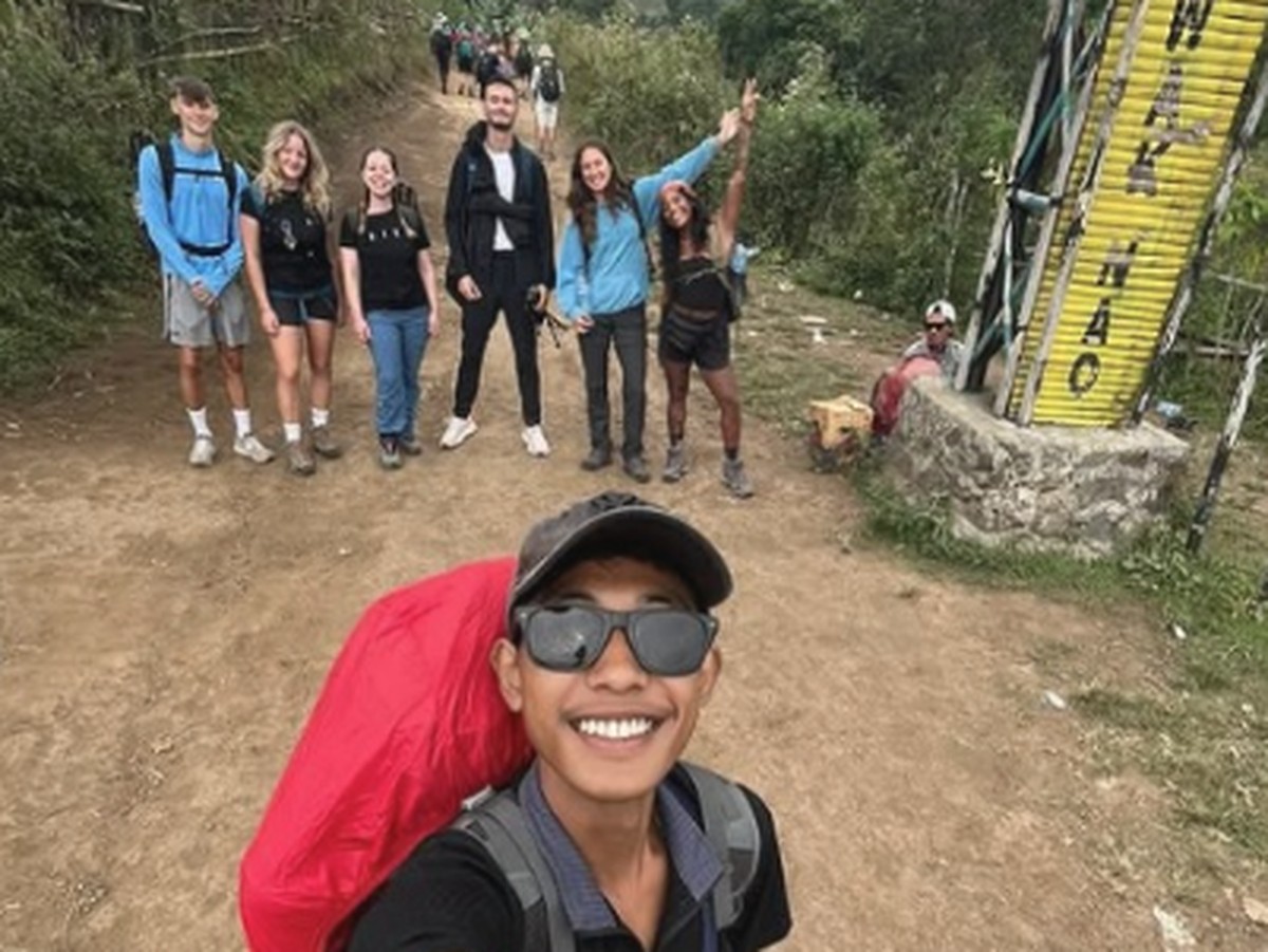Juliana Marins revela últimos momentos e lamenta não poder visitar vulcão na Indonésia Ali Musthofa, à frente da selfie, levava Juliana Marins e outros turistas por trilha do Monte Rinjani (Foto: Instagram)