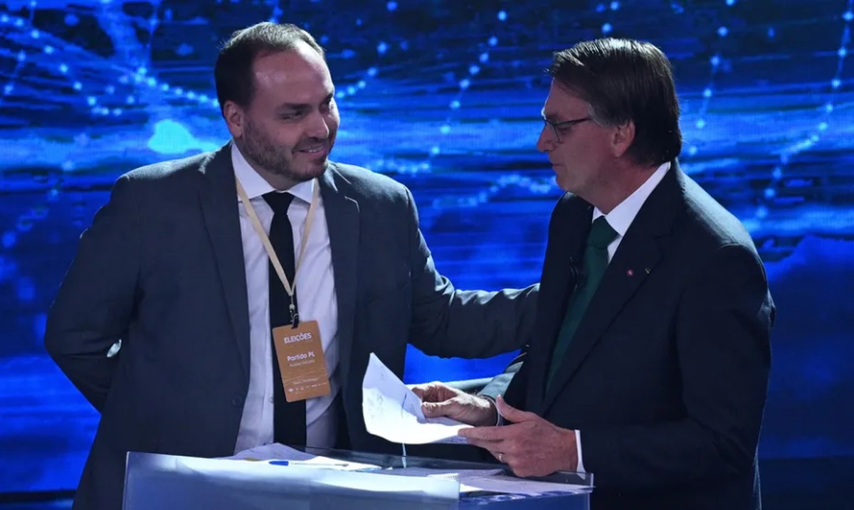 O presidente Jair Bolsonaro (PL) e o filho Carlos Bolsonaro (Republicanos), durante debate presidencial da Band no segundo turno (Foto: Nelson Almeida / AFP)