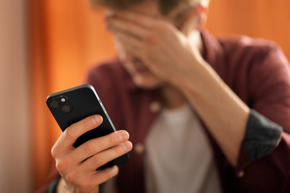 O impacto de 8 horas diárias no celular na saúde do corpo humano Imagem ilustrativa de um jovem utilizando o celular por 8 horas seguidas (Foto: Reprodução/Freepik)