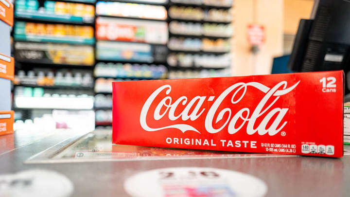 Coca-Cola divulga resultados financeiros com lucro acima do esperado e receita abaixo Uma embalagem com 12 latas de Coca-Cola é exibida em um balcão de uma loja 7-Eleven em Austin, Texas, em 17 de julho de 2025. (Foto: Brandon Bell | Getty Images)