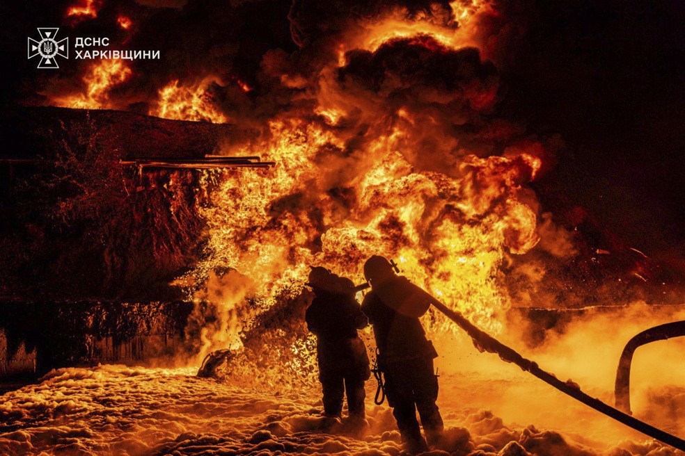 Rússia realiza o maior ataque com drones da guerra contra a Ucrânia Agentes dos serviços de emergência trabalham para apagar um incêndio após um ataque russo na região de Kharkiv, Ucrânia, neste sábado (Foto: Serviço de Emergência da Ucrânia)