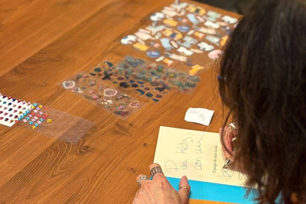 Rosa Montero realiza maratona de autógrafos de mais de 4 horas em Paraty A escritora espanhola Rosa Montero, uma das principais autoras da 23ª Flip, decora suas dedicatórias com adesivos durante sessão de autógrafos que durou mais de 4h em Paraty (Foto: Divulgação)