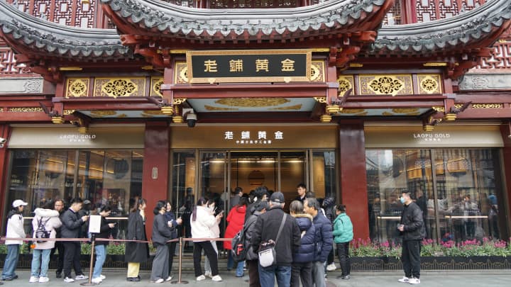 Ações da Laopu Gold caem mesmo com previsão de lucro triplo na China Clientes fazem fila em frente à Laopu Gold Store em Xangai, China, 27 de fevereiro de 2025. (Foto: Cfoto | Future Publishing | Getty Images)