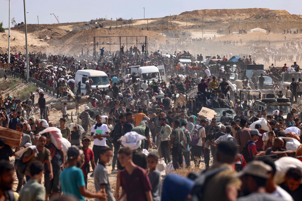 Palestinos buscam ajuda humanitária no chamado 'corredor Netzarim', no centro da Faixa de Gaza (Foto: AFP)