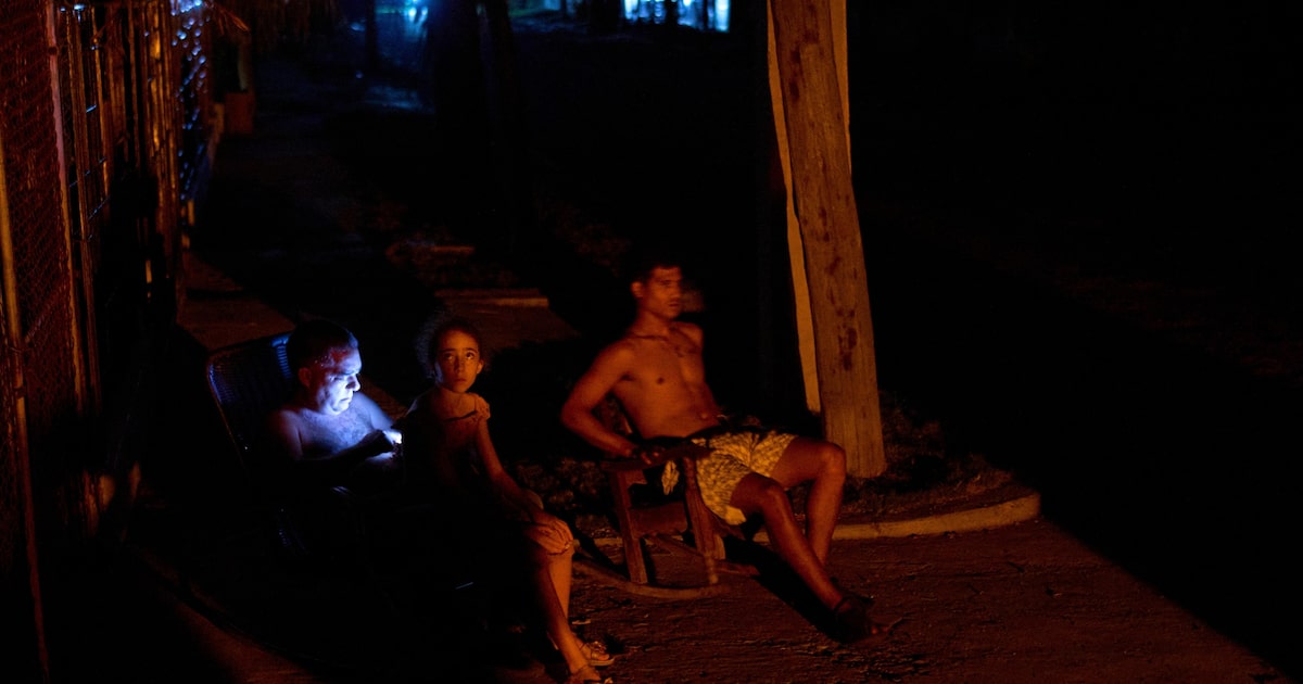 Cuba enfrenta crise profunda com falta de luz, turistas e recursos financeiros Cubanos sentam na rua durante um apagão em Havana (Foto: Ramon Espinosa/AP)