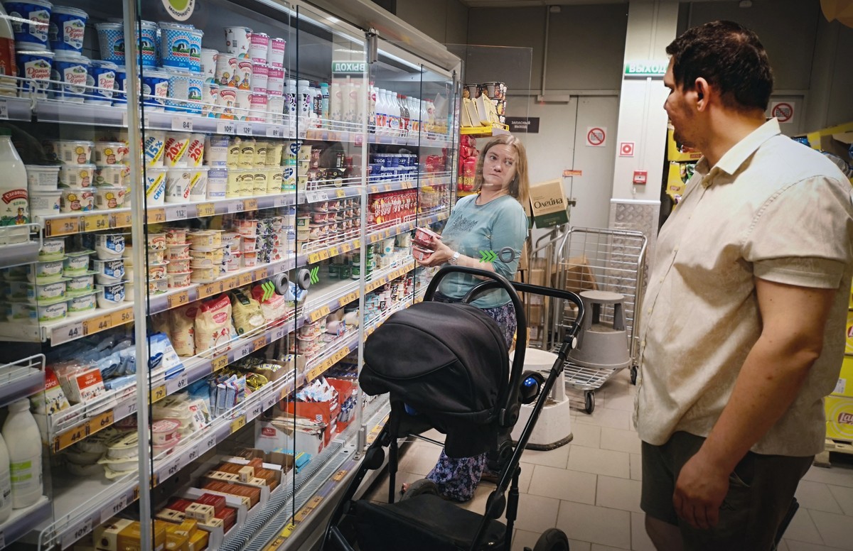 Classe média russa adota carro chinês e viaja para férias na Venezuela Maria Tyabut e seu marido Sergei Duzhikov escolhem comida em uma loja no subúrbio de Mytishchi, em Moscou (Foto: NEMENOV / AFP)